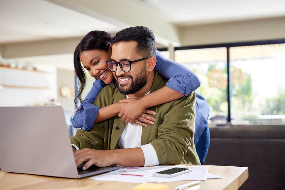 happy couple working on laptop