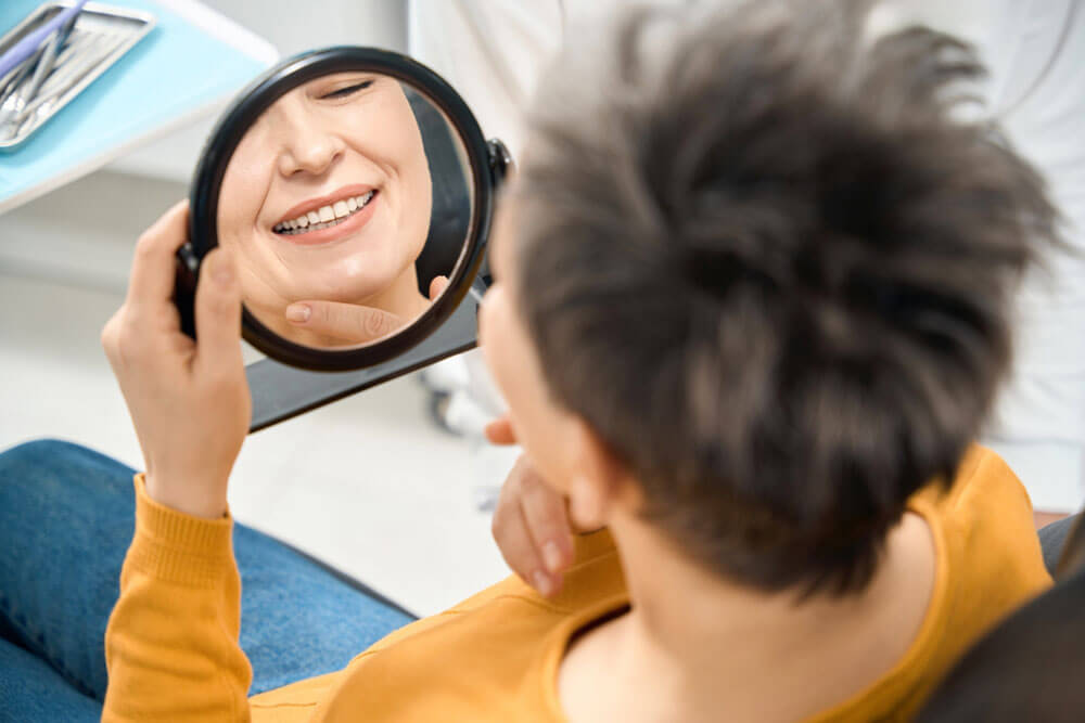 Woman client checking her smile and state of teeth