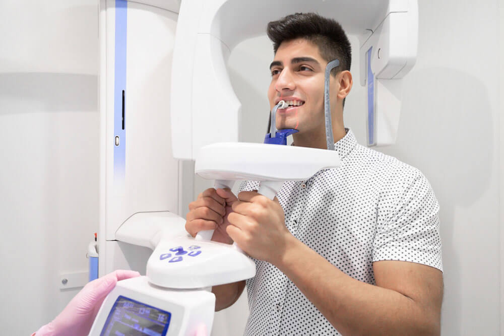 Young man patient standing in x-ray machine
