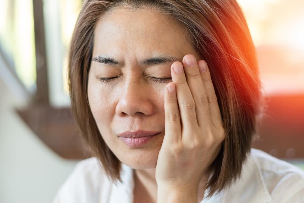 Woman hand on cheek face as suffering from facial pain