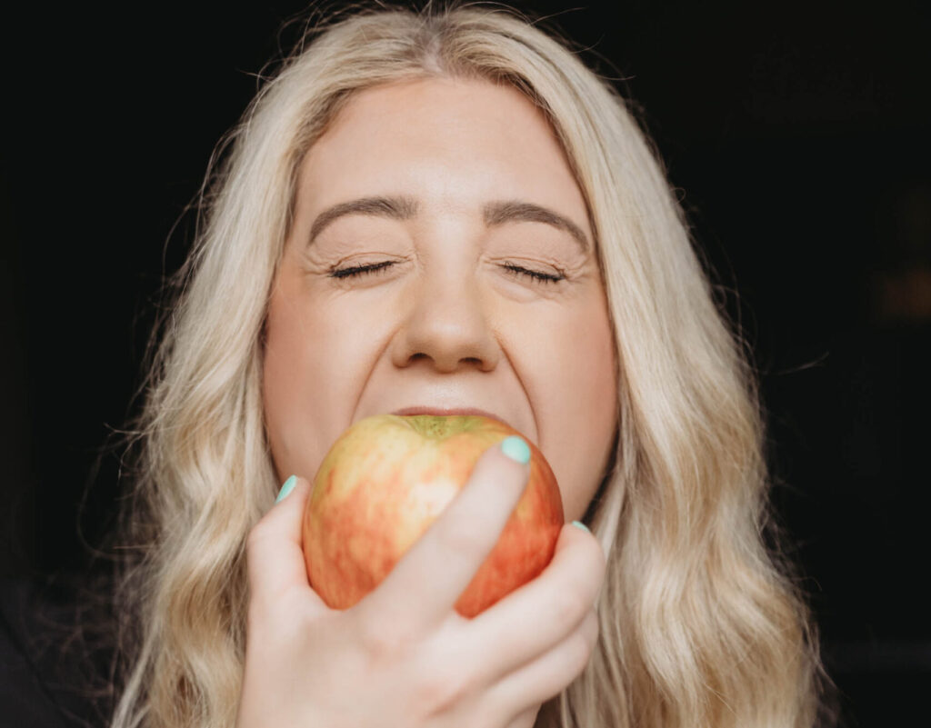 Shelby Fritts biting an apple