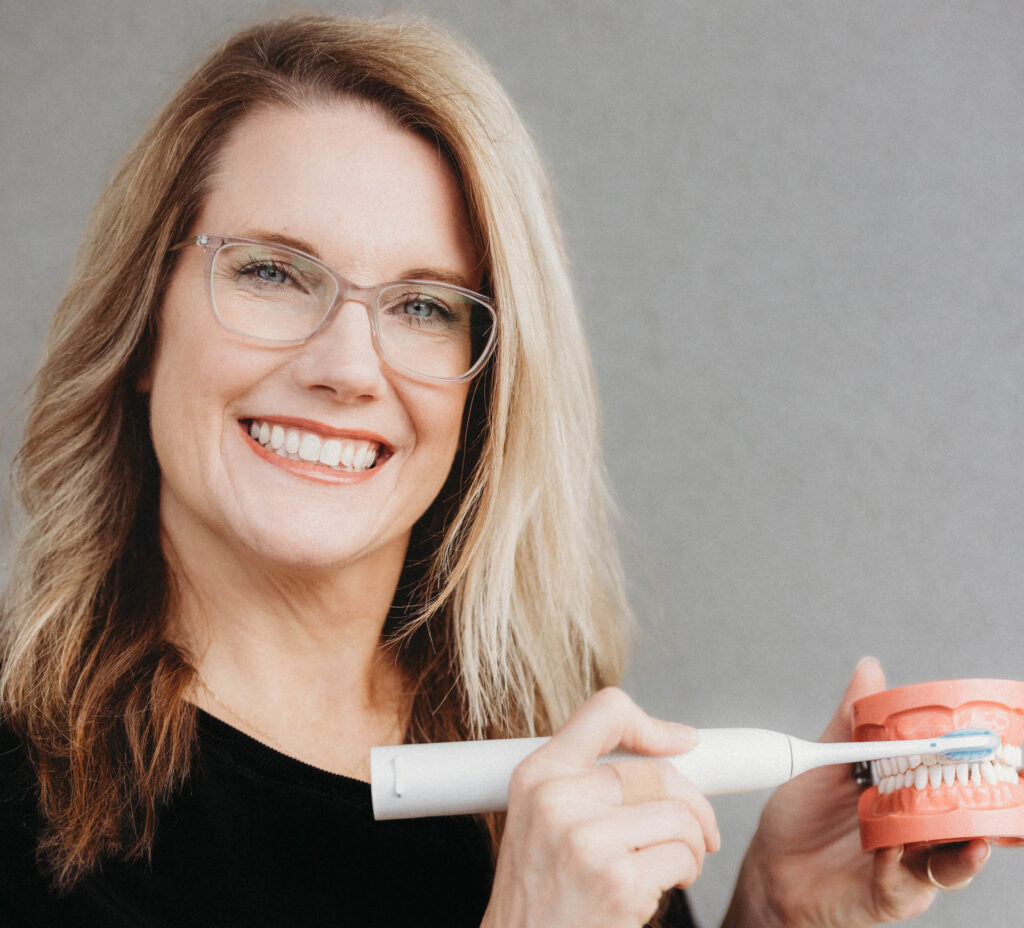 Summer McCain brushing a tooth model