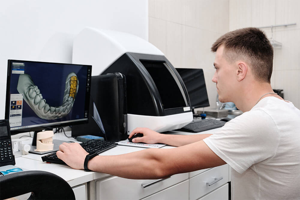 dental technician using computer-aided design (CAD) software to create a 3D model of a dental restoration,