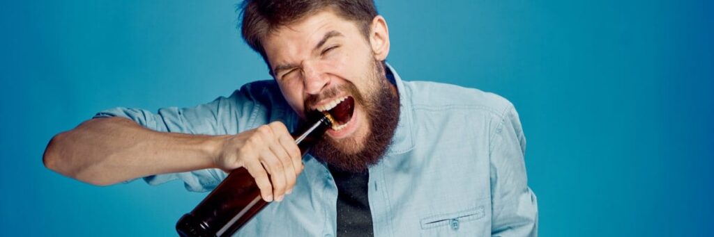 Man opening bottle with teeth