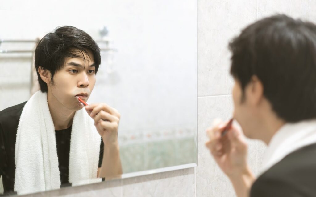 sad man brushing teeth