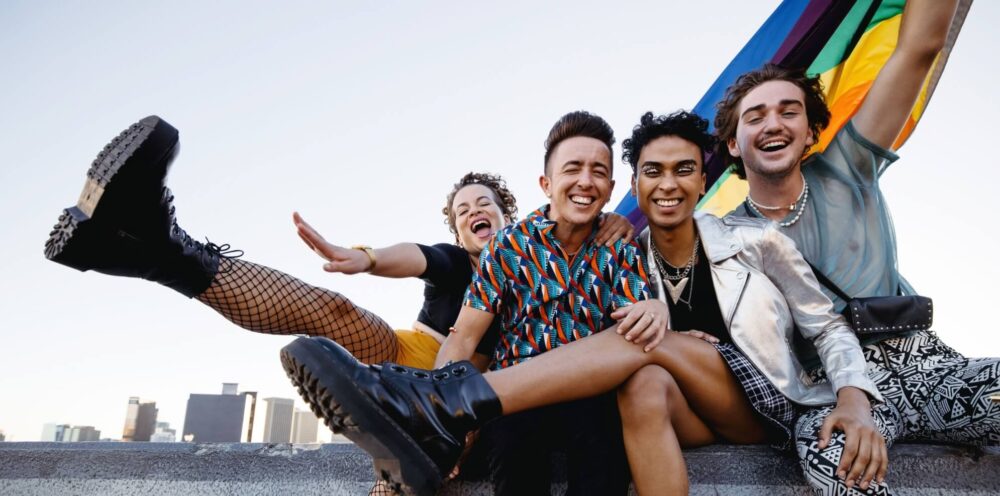 Four LGBTQ people celebrating pride while sitting together