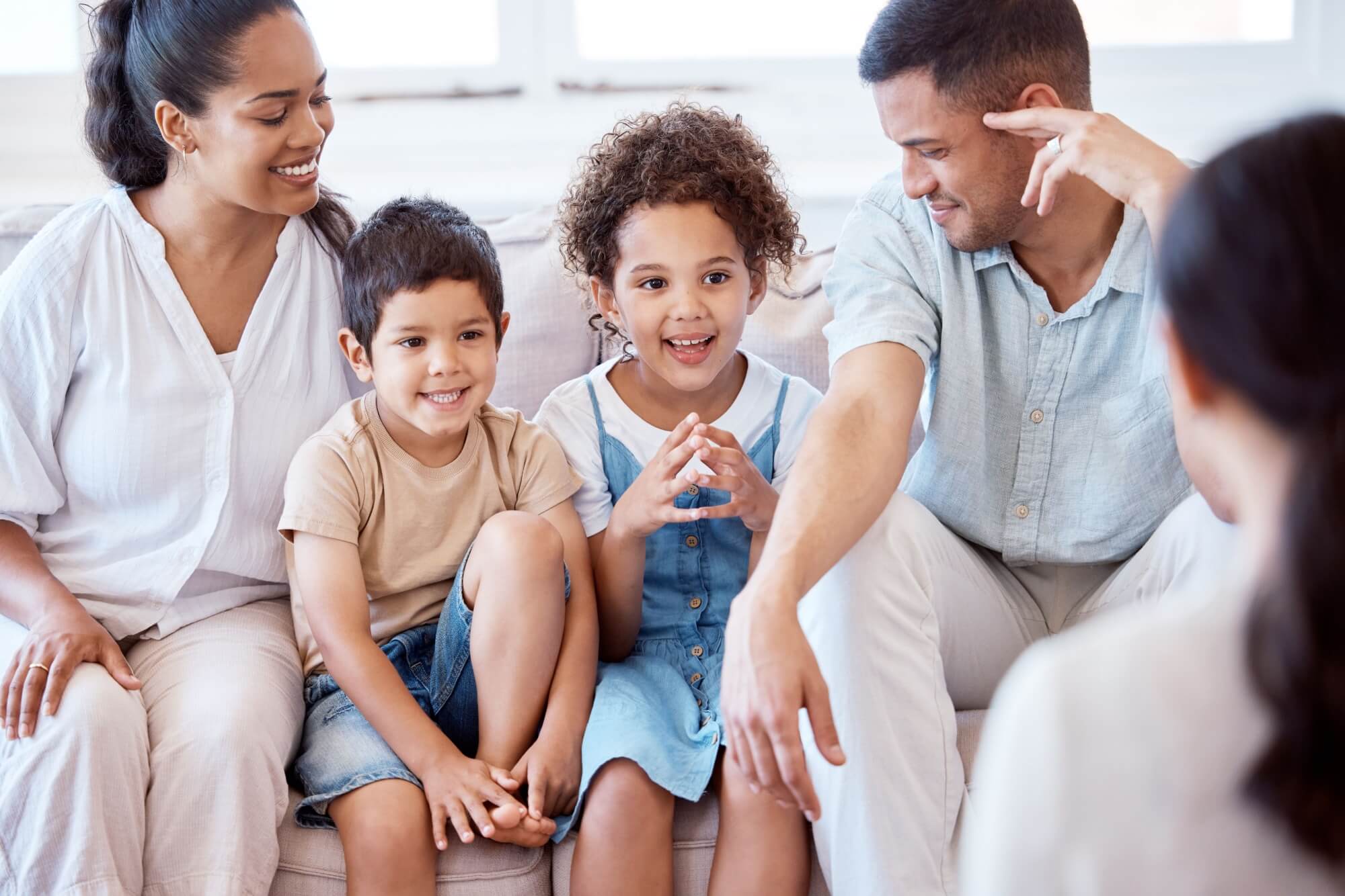 Parents, kids and counselling with psychology, smile and together on sofa, support and discussion