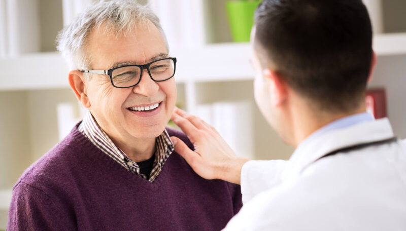Older man smiling with medical doctor