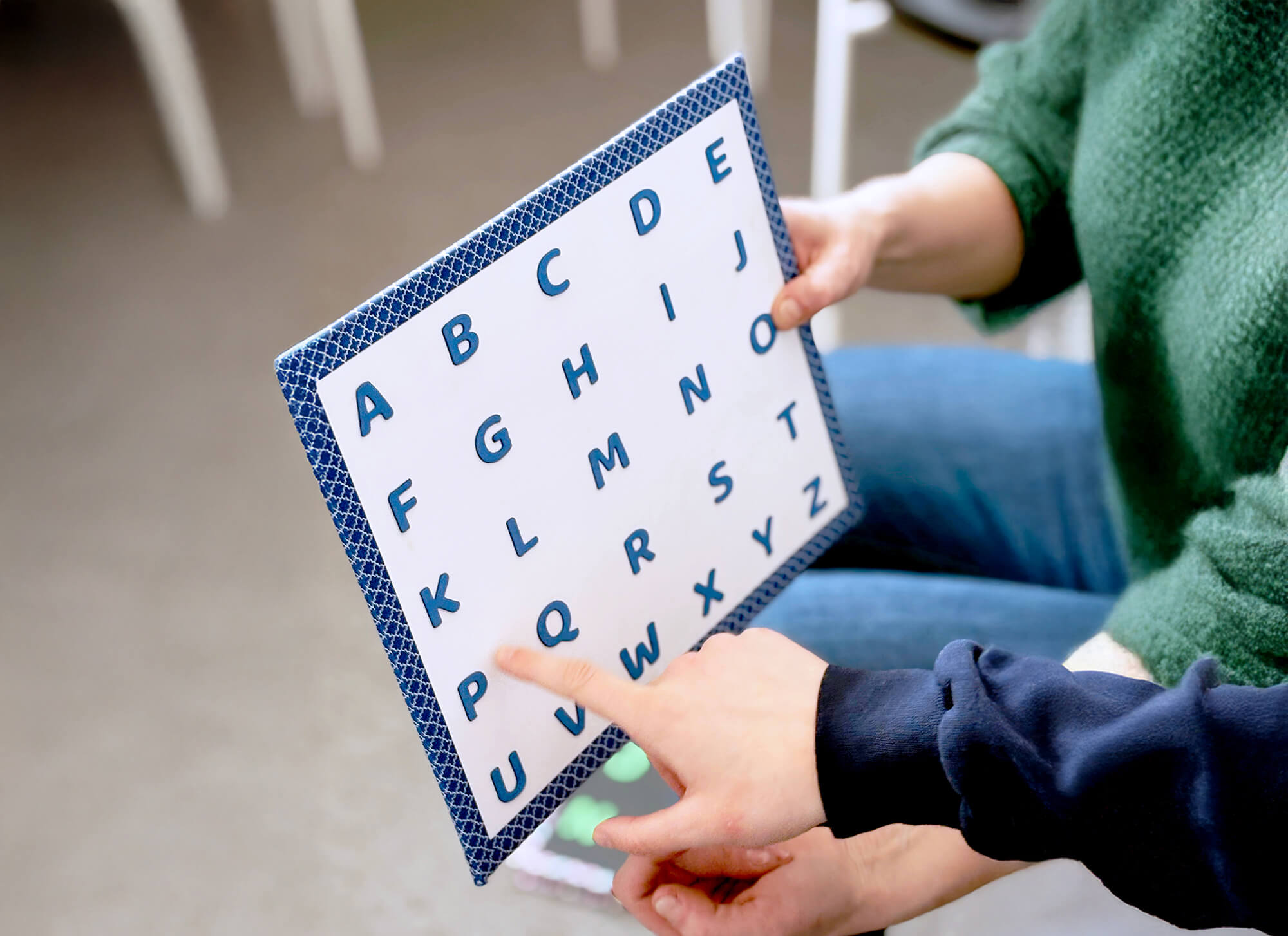 Kid pointing to a letterboard