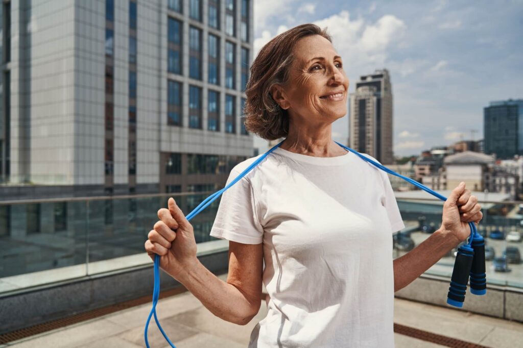 Happy mature woman relaxing after jumping training