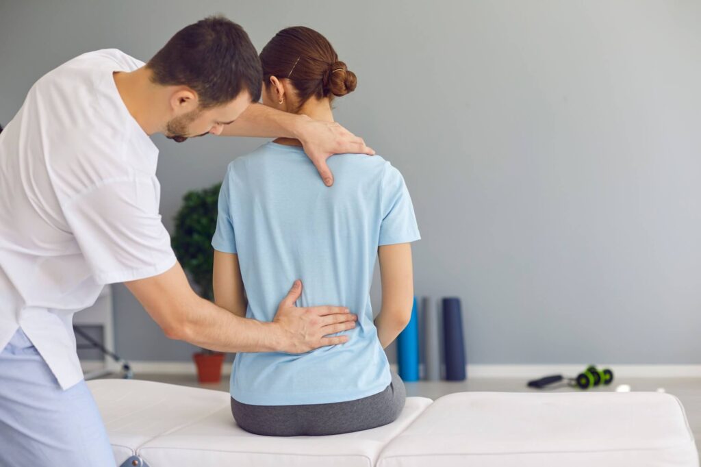 Professional osteopath or chiropractor fixing woman patients back muscles during rehabilitation therapy
