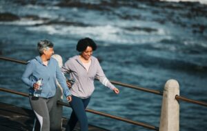 Fitness, exercise and senior women by ocean for healthy body, wellness and cardio