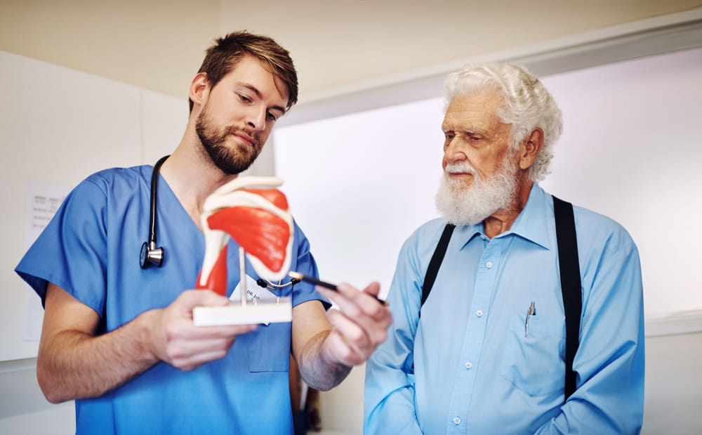 Anatomy, model and doctor with mature patient for demonstration for surgery, diagnosis and consulting.