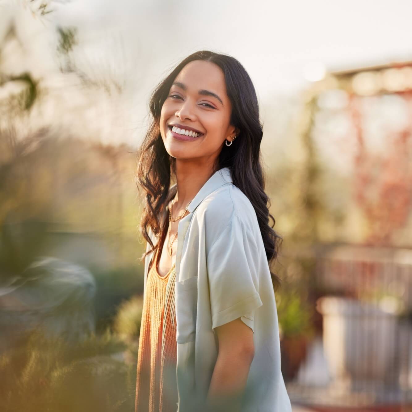 Young Latin woman in casual clothing in the garden looking at camera