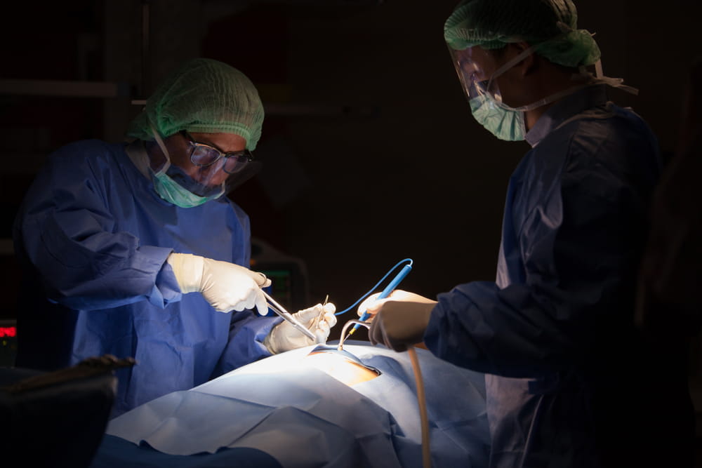 Concentrated doctor, assistant and nurse in a patient during a hysterectomy operation in a hospital