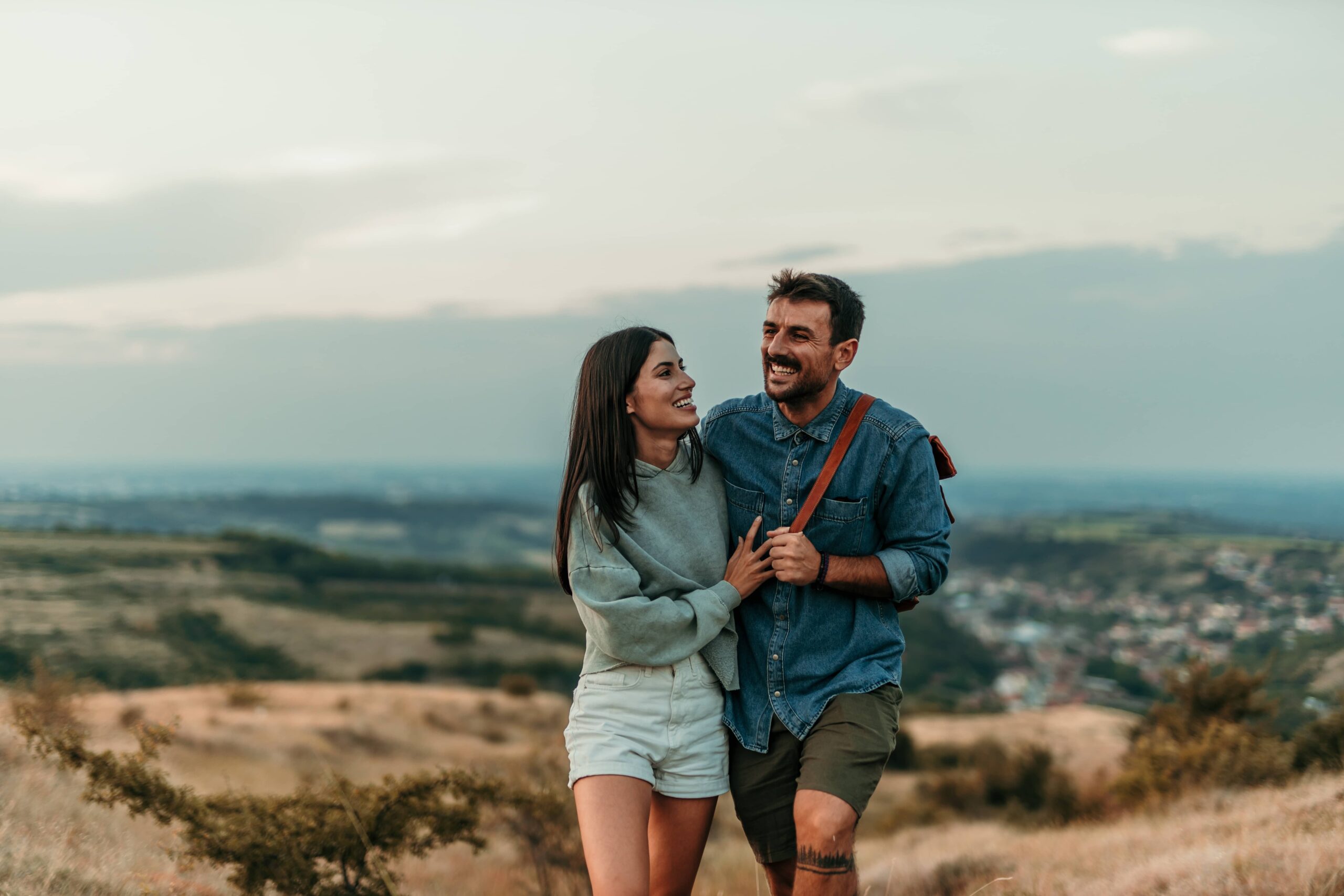 A smiling couple walking and enjoying a quiet moment together in a vast meadow