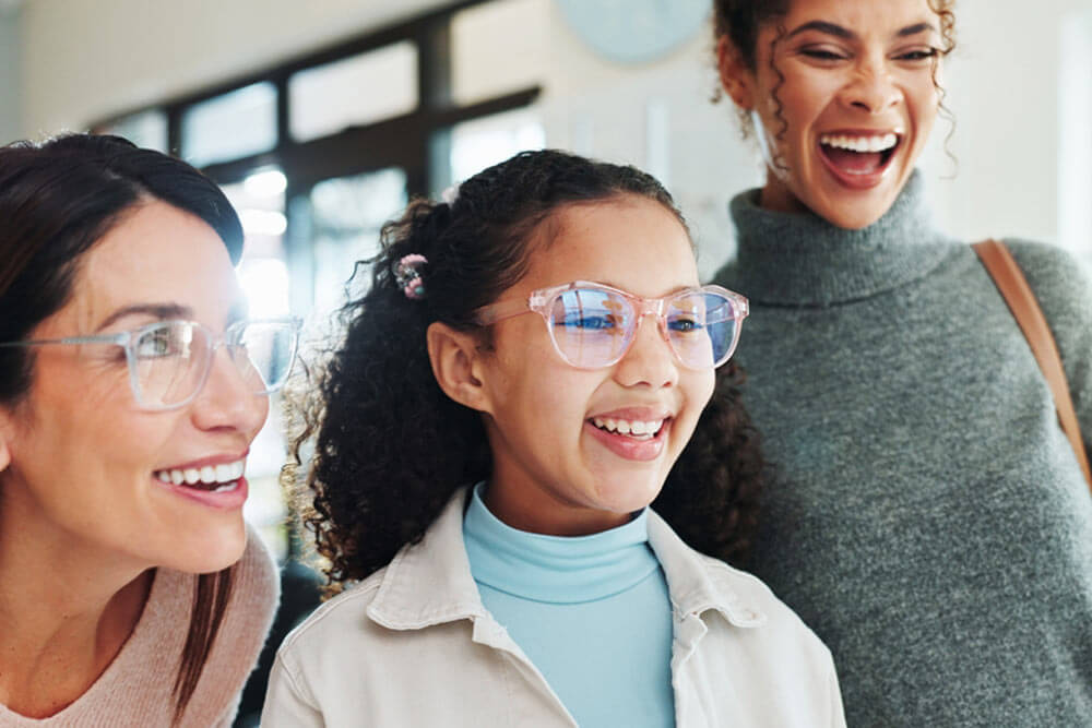 Happy, family or optometry with girl and woman in hospital for appointment, checkup and eye care