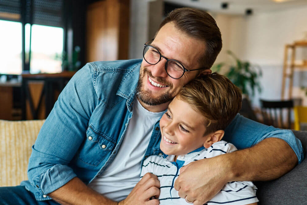 Portrait of a happy teenage boy son and his father at home