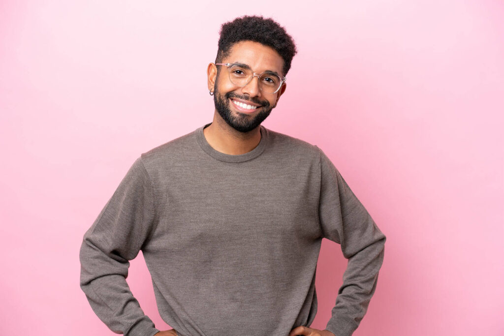 Young man with arms at hip and smiling