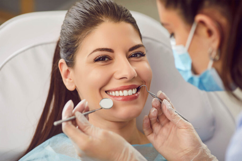 Dentist examining the teeth of a happy patient