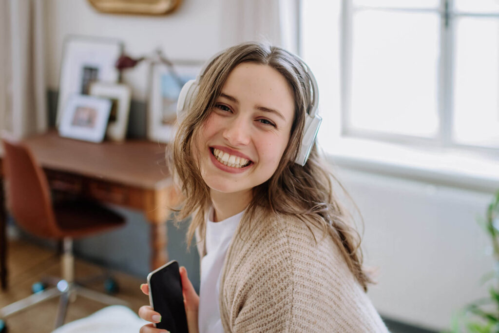 Young woman listening music trough headphones