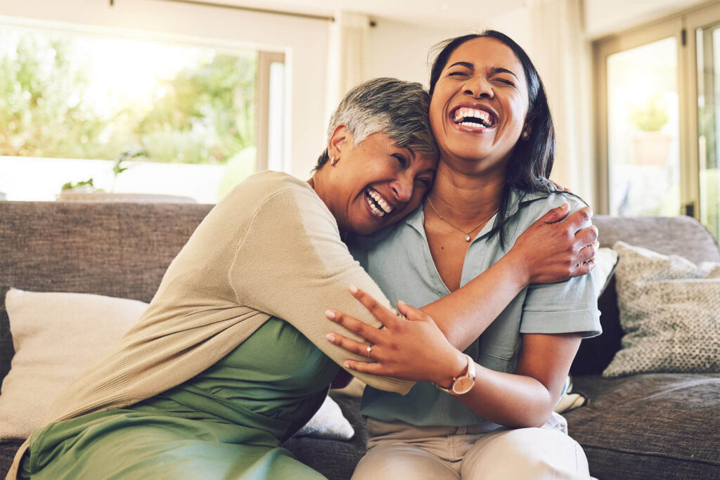 Happy, elderly woman embrace young woman