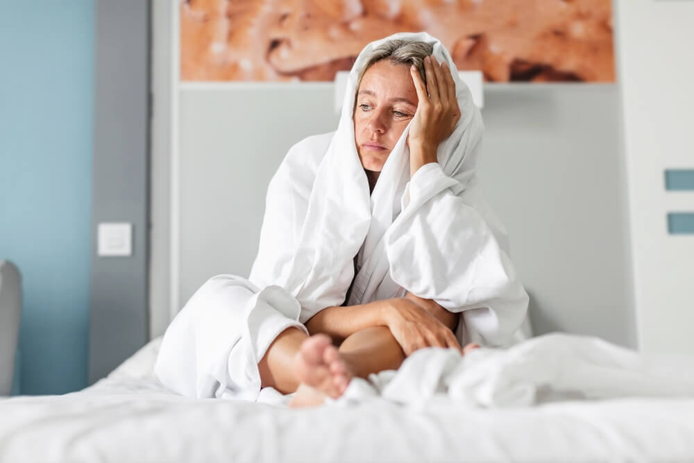 Sleepless middle-aged woman lying in bed suffers from insomnia