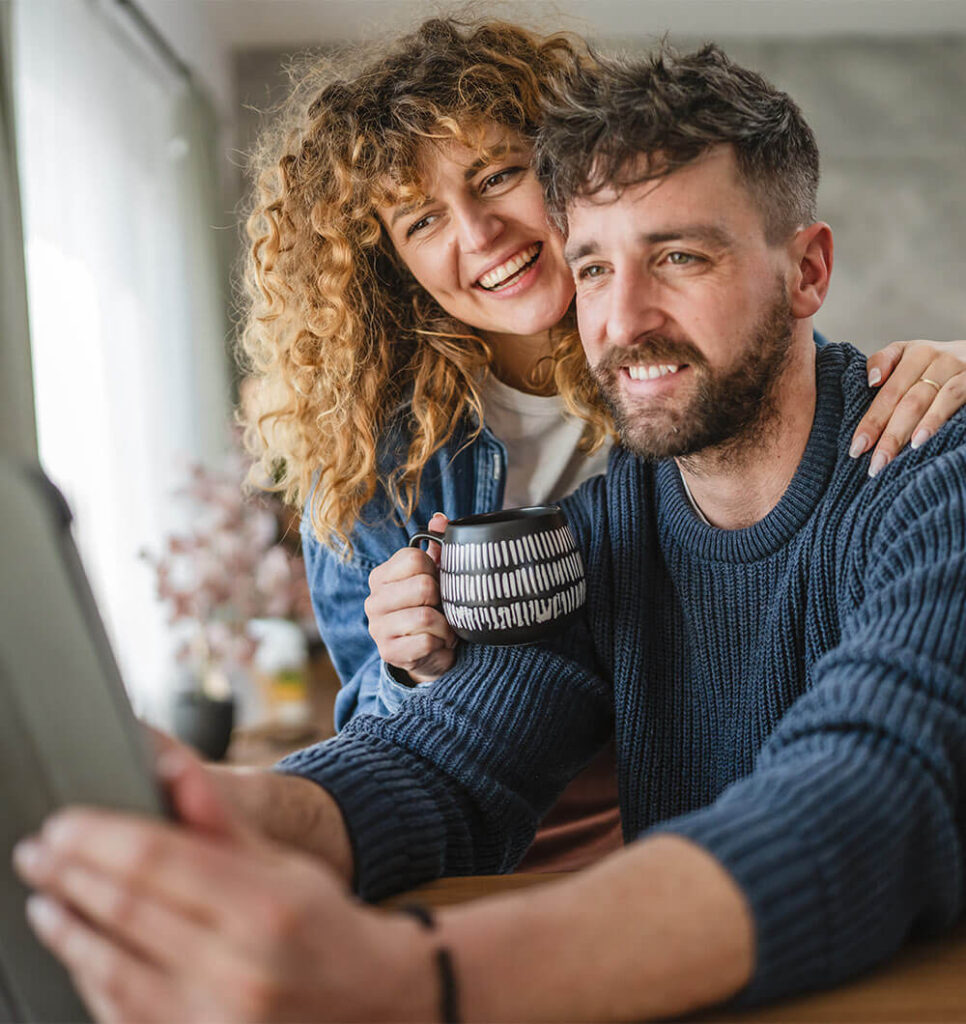 A happy adult couple sit in a cozy home setting