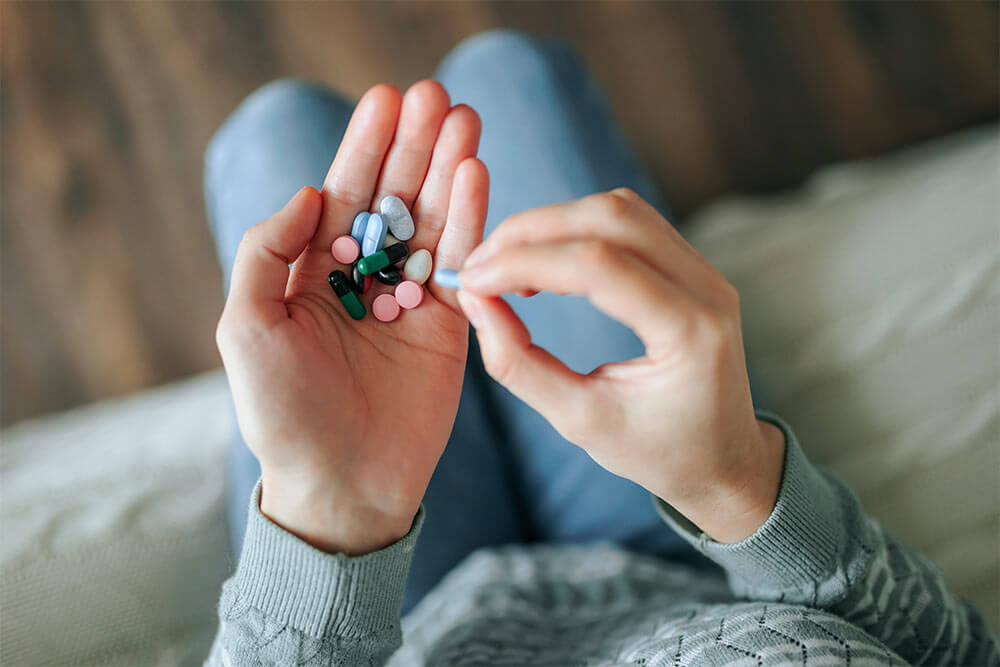 Woman take pills from the palm of her hand