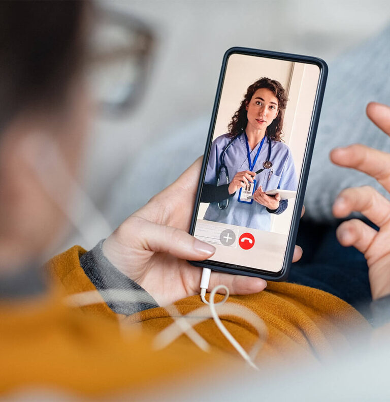 Woman patient in conversation with specialist over video conferencing using smart phone