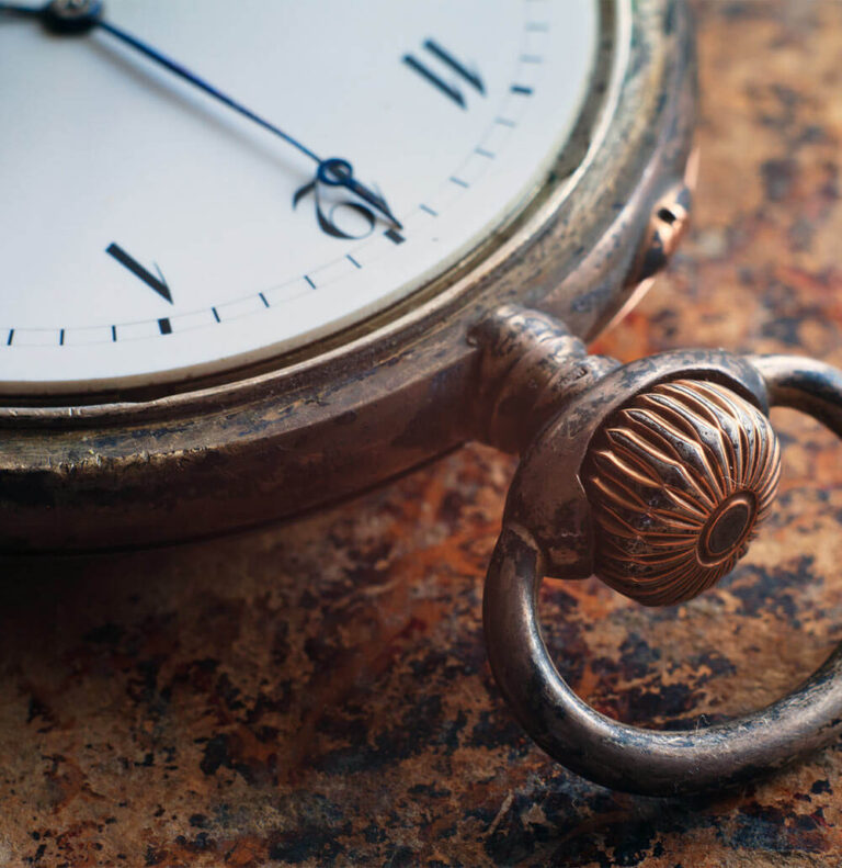 gears and mainspring in the mechanism of a silver pocket watch