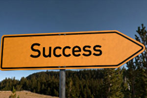 a yellow, arrow-shaped road sign with the word "Success"