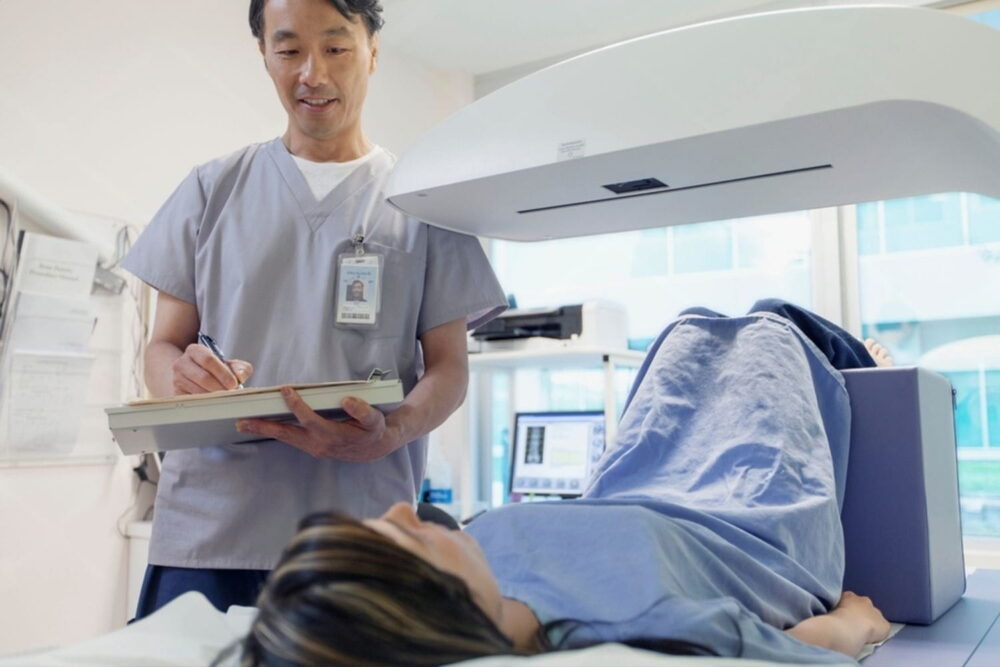 technician taking information from patient about to have bone density scan