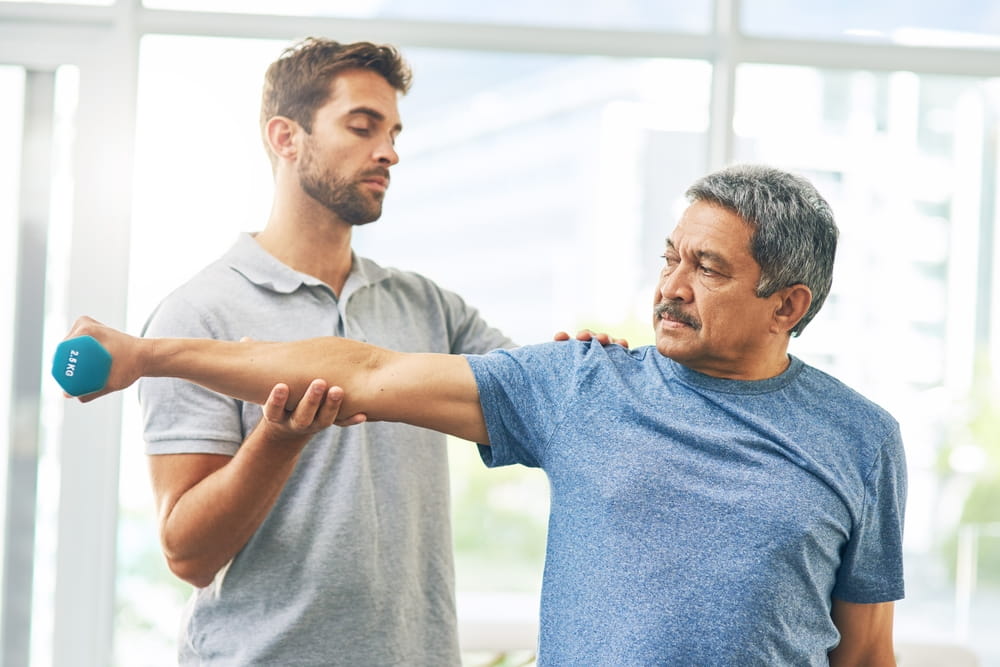 Elderly patient, exercise and dumbbell with physiotherapist for rehabilitation, wellness and muscle fitness