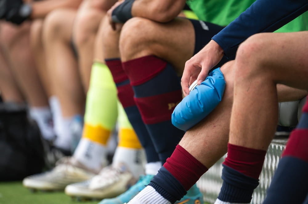 The injured footballer lies on the pitch.