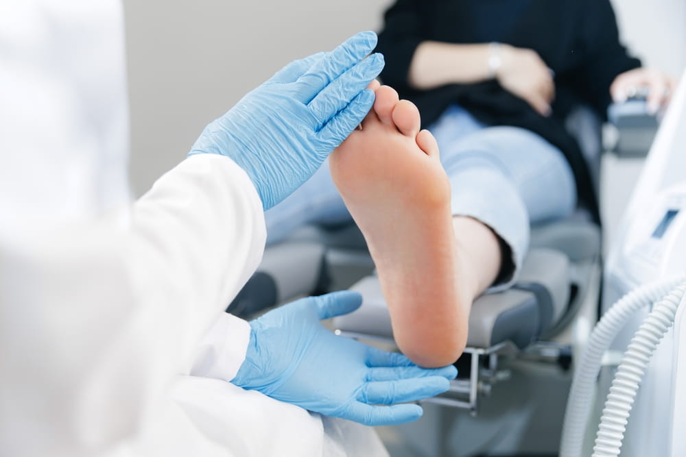 Podiatrist examining female patient foot in medical office.
