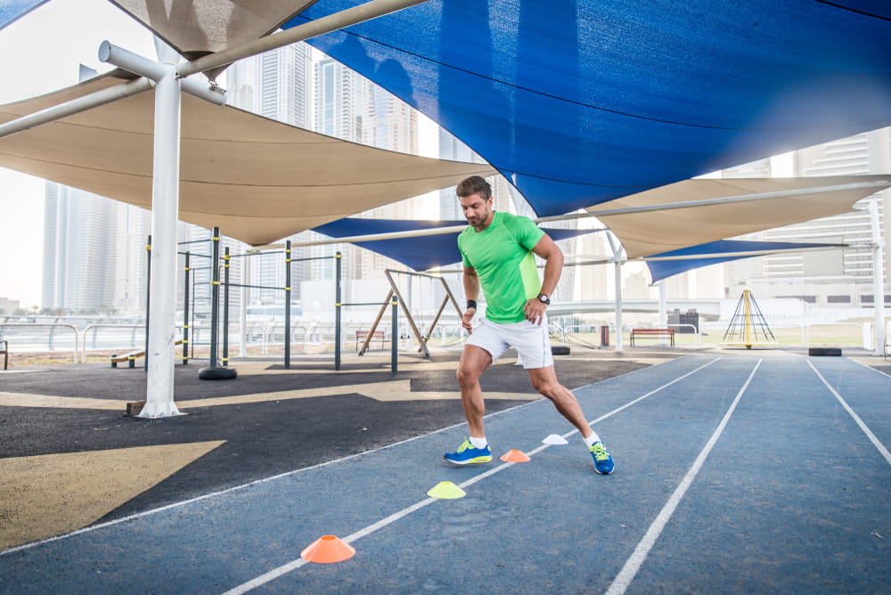 Young athletic man training outdoors - Young adult doing a fitness workout