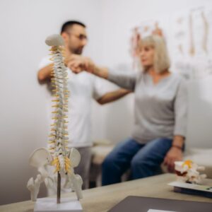 Happy senior woman lying on exam couch while chiropractor