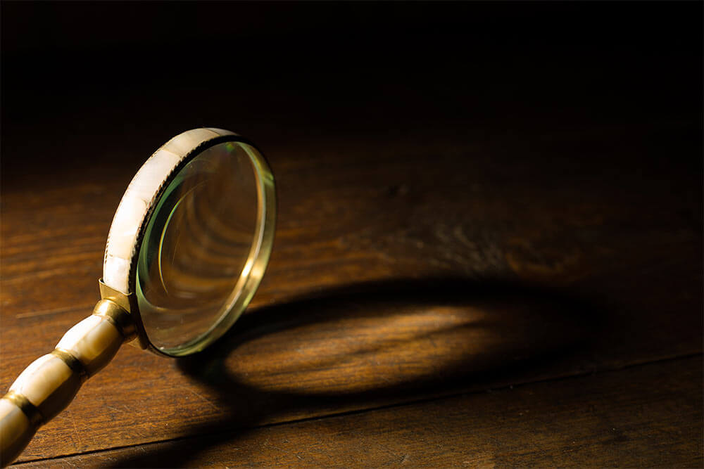 Vintage magnifying glass on wooden table