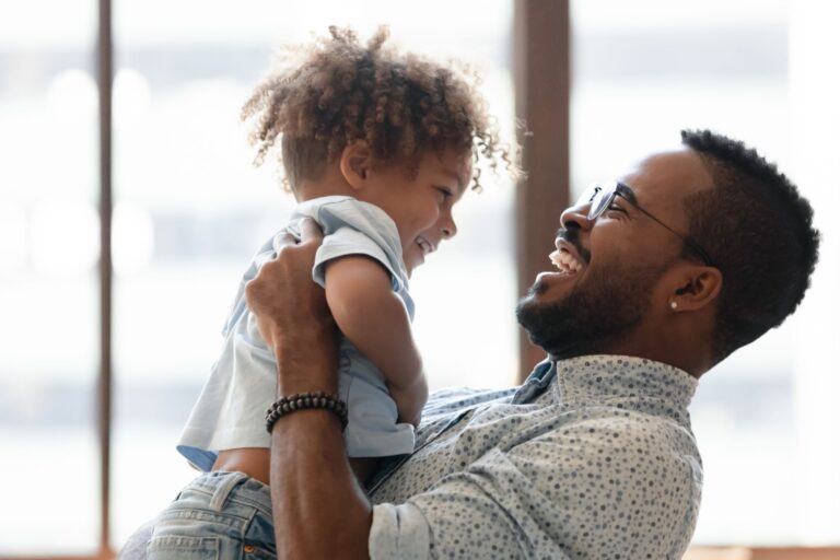 Happy daddy holding kid in arms