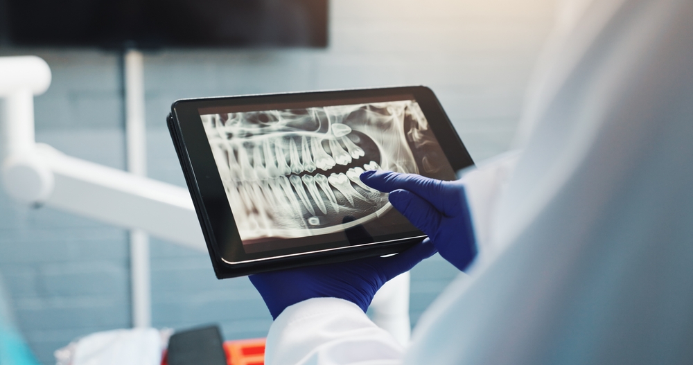 Hands, dentist and tablet screen for x ray, tooth diagnosis or planning for healthcare treatment