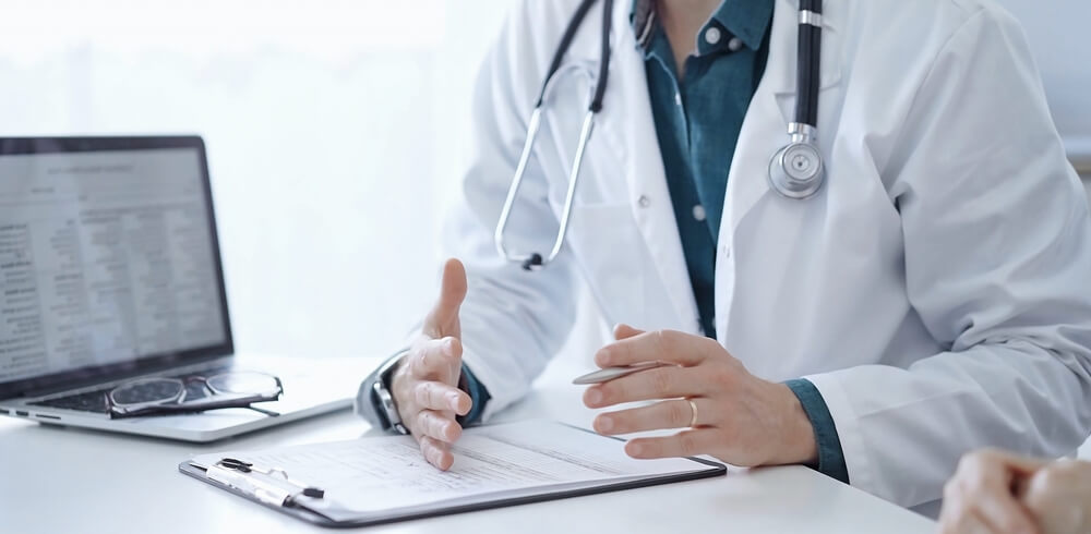 Doctor and a patient. The physician, wearing a white medical coat