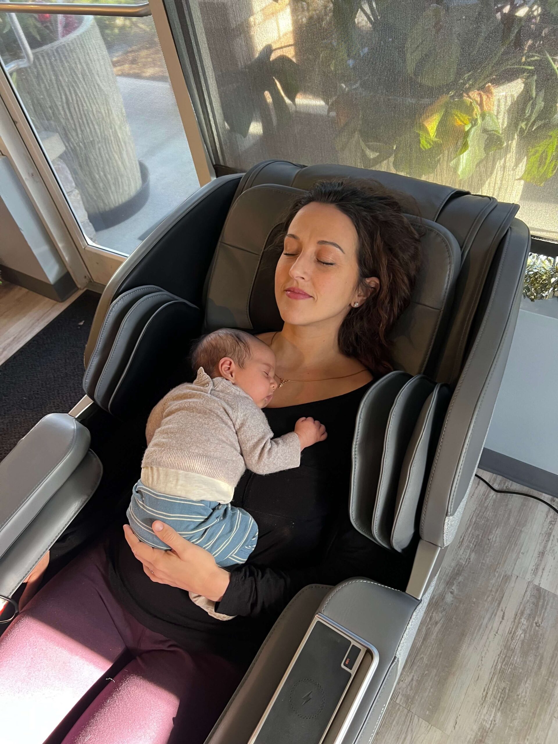 woman on massage seat carrying her baby