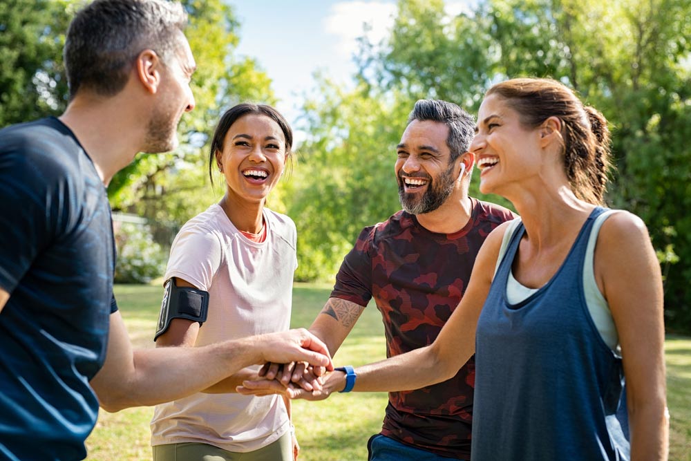 Laughing mature and multiethnic sports people at park