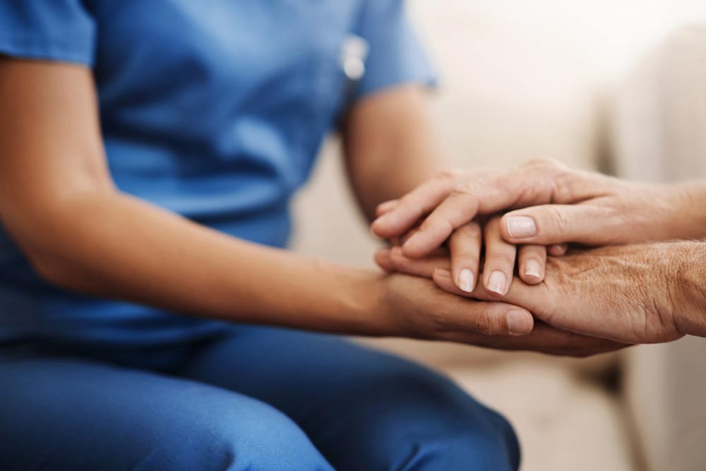 senior woman holding hands on sofa for healthcare