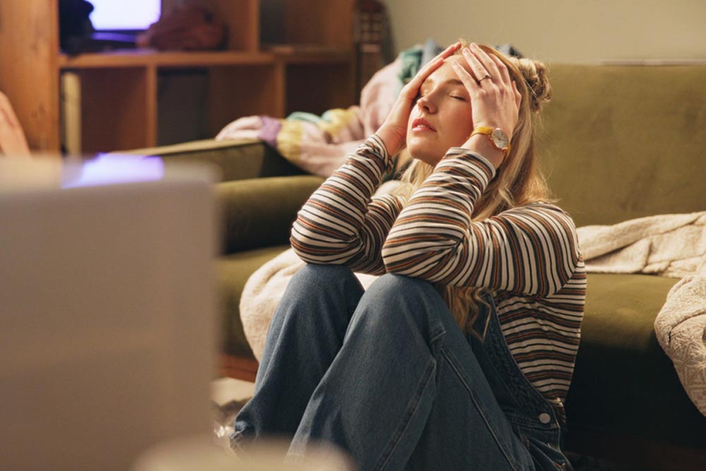 Woman, stress and moving on floor in house with anxiety