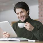 man-checking-emails-while-having-morning-coffee