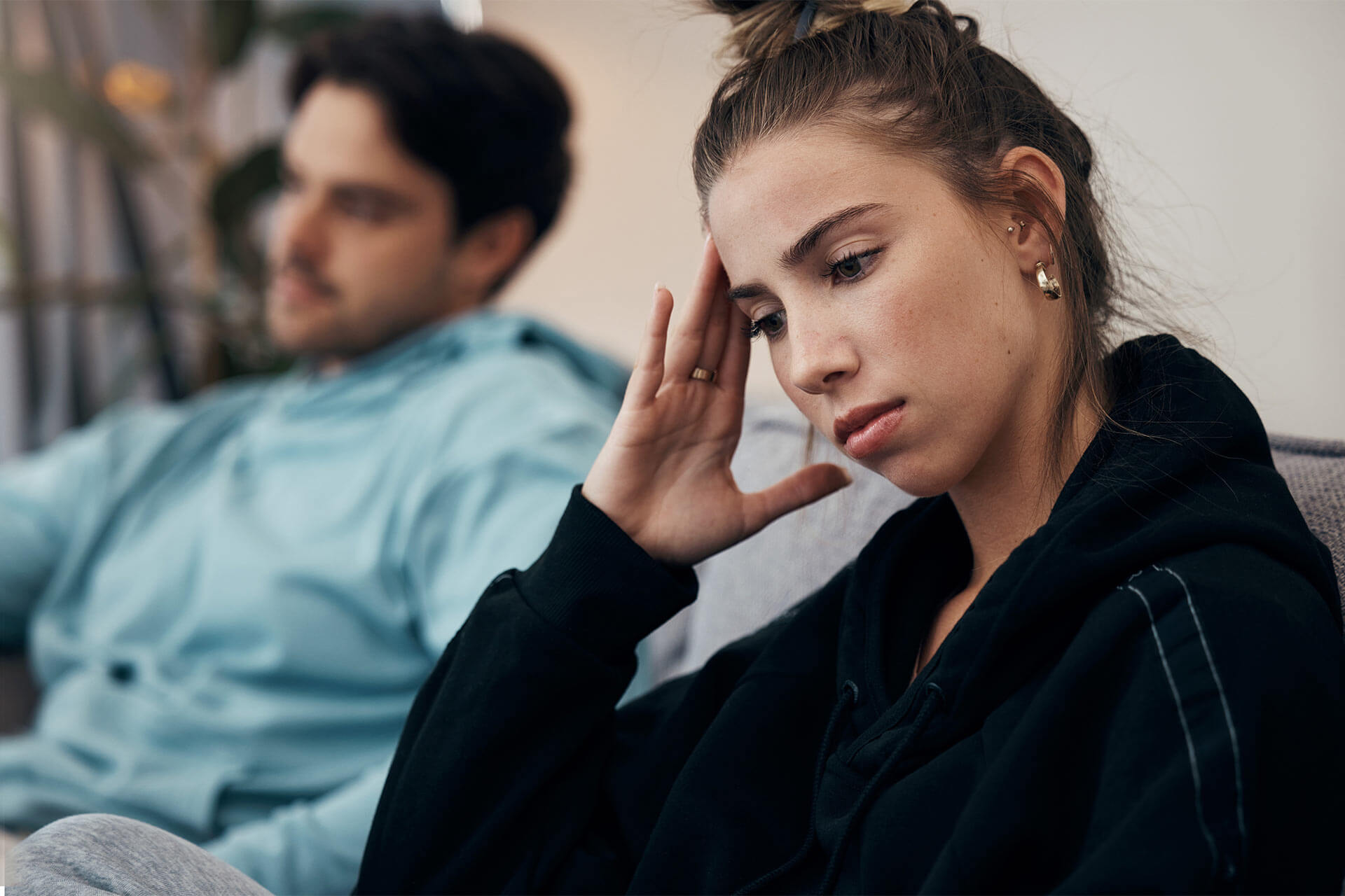 Frustrated couple, headache and fight on sofa in divorce, disagreement or conflict in living room at home.
