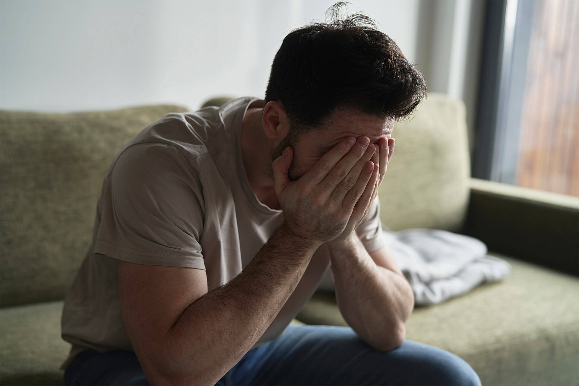 Broken man at home on sofa
