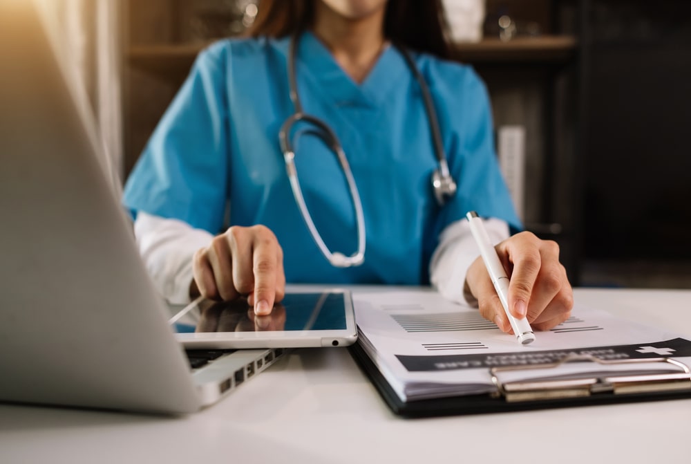 Doctor working with mobile phone and stethoscope on digital tablet